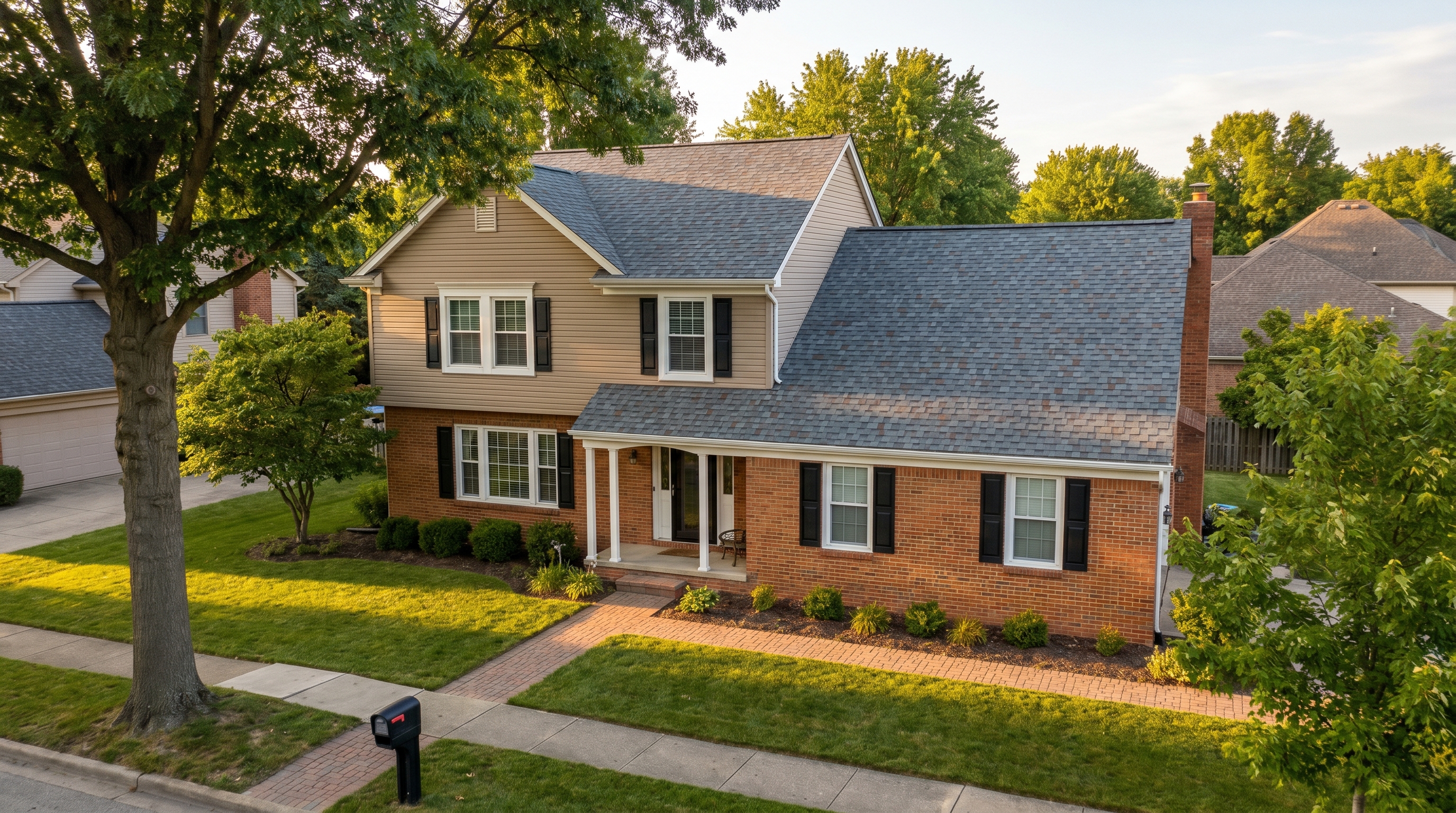 A two-story brick and siding Northeast Ohio home with a new architectural shingle roof by Crest Roofing